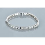 A white precious metal and diamond set tennis bracelet, set with thirty-eight circular cut diamonds,