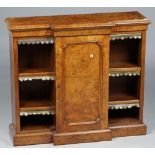 A Victorian figured walnut floor standing bookcase with central panel cupboard,