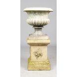 A 19th century stoneware garden urn with semi fluted body and turned socle on leaf moulded square