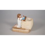 A Russian biscuit porcelain figure depicting a young kneeling girl playing with dolls,