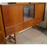 A mid 20th century Danish teak drinks cabinet with central glass section flanked by sliding doors