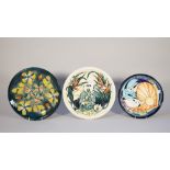 Three Moorcroft Pottery plates comprising; water lilies against a cream ground, 26cm diameter,
