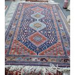 A Shiraz rug, Persian, the indigo field with two indigo and two madder medallions,