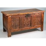 A 17th century oak coffer, with carved triple panel front, on block feet, 146cm wide x 75m high.