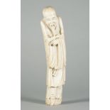 A Chinese ivory figure of an Immortal, 19th century carved wearing long robes and a cloth hat,