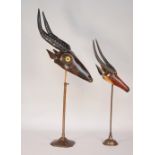 A Black Forest style hardwood carved antelope with glass eyes on an adjustable metal stand,