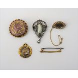 A gold brooch, glazed with an oval hair locket compartment to the centre,