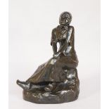 A late 19th century patinated bronze figure of a Dutch lady seated on a rock,