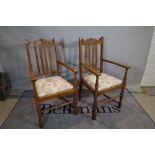 A pair of mid-20th century oak open armchairs with stick backs on block end turned supports,