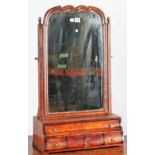 A Queen Anne figured walnut dressing mirror, the shaped plate over a graduated four drawer base,