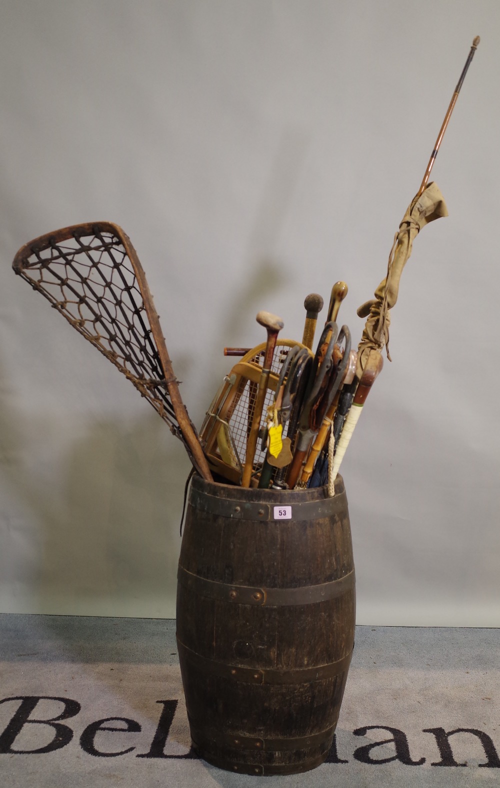 A 19th century oak and iron bound coopered barrel containing various walking sticks and umbrellas