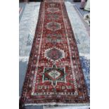 A Kasajar runner Persian, the madder field with seven bold medallions, flowerheads,