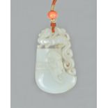 A Chinese white jade pendant, Qing dynasty, in the form of an archaistic axe,
