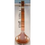 An Indian sitar with carved wood and ivory inlaid foliate decoration, applied trade label 'R.S.