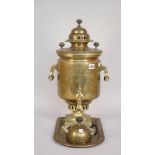 A Russian brass samovar, circa 1900, with twin handles over a square foot and four shaped feet,