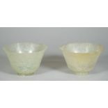 A pair of Chinese green jade cups, Qing dynasty, rising from a short foot to a flared rim,