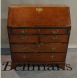 A late George III oak bureau of two short and three long drawers on bracket feet 91cm wide x 103cm,