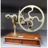 A nickel-plated watchmaker's wheel-cutting machine, with a rectangular wooden base,