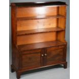 A 19th century mahogany waterfall bookcase with four open tiers over a pair of panel cupboards on
