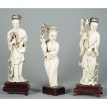A pair of Chinese ivory figures of young women, early 20th century, each standing in long robes,