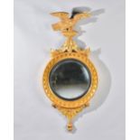 A William IV gilt framed convex mirror with eagle crest and star burst lower frieze,