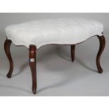 A mahogany framed footstool, with button upholstered serpentine shape top on cabriole supports,
