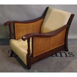 A 20th century hardwood low armchair with cane back.