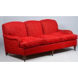 Kingcome Sofas; a modern red upholstered triple hump back sofa on turned supports,