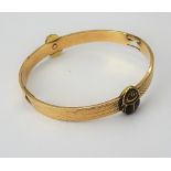 A gold and pale brown enamelled bangle, formed as two scarabs with wings,