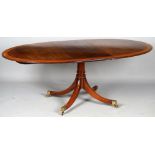 A George III style satinwood banded mahogany oval extending dining table on turned column and four