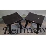 A pair of 20th century black painted hardwood low side tables on tapering supports,