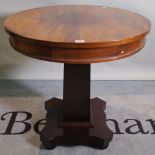 A 20th century mahogany circular centre table on ebonised tapering column on bun feet,