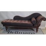 A Victorian mahogany purple upholstered chaise longue with shaped back and turned tapering supports,