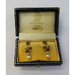 A pair of yellow precious metal, diamond and cultured pearl pendant earrings, of bow design,