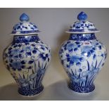 A pair of Asian blue and white large lidded vases, (2).