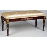 An Empire Revival rectangular stool,the padded top on parcel gilt fluted corn sheaf supports,