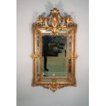 An 18th century style Italian mirror the opposing 'C' scroll crest centred by a female face mask,