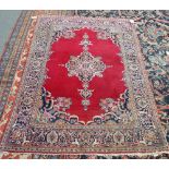 A Kashan rug, Persian, the plain madder field with a central medallion,