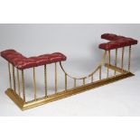 A Victorian style brass and burgundy leather upholstered club fender,