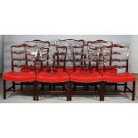 A set of seven George II style mahogany ribbon back dining chairs with concave seat on canted