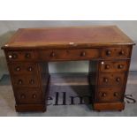 A late 19th century oak pedestal desk with nine drawers and red leather inset top,
