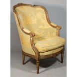 A Louis XVI style tub back armchair with foliate carved green painted frame on tapering fluted
