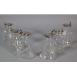 A matched set of six glass and silver topped small jugs, (6).