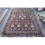 An Amritsar rug, the burgundy field with ivory and sage round flower heads,