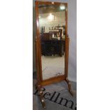An Edwardian mahogany and inlaid cheval mirror on outswept supports,