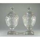 A pair of cut glass urns and covers, 19th century, each cut with bands of raised diamonds,