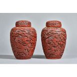A pair of Chinese cinnabar lacquer vases and covers, Qing dynasty, of ovoid form with domed covers,