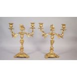 A pair of Louis XV style gilt metal twin branch candelabra, each raised on three scroll feet,
