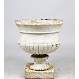 A Victorian white painted cast iron jardiniere with semi fluted body on turned socle and square