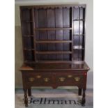 A late Victorian oak dresser with three tier plate rack over two drawers.